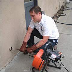 Tracy plumbing associate clears drain with power augur